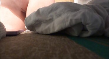 La chica mete cuidadosamente un arnés negro en la tierna vagina de una morena bronceada en el sofá de cuero